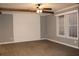 A spacious living room with gray walls, ceiling fan, wooden beams, and window with blinds at 7382 Knox Bridge Hwy, Canton, GA 30114