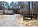 Expansive yard with mature trees, fence line, and graveled driveway leading to a cozy house at 7382 Knox Bridge Hwy, Canton, GA 30114