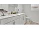 Well-lit bathroom featuring double sinks, quartz countertop, and a modern toilet at 7438 Jennadee Dr, Fairburn, GA 30213