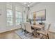 Bright dining room with large windows, modern light fixture and adjacent views into the living room at 7438 Jennadee Dr, Fairburn, GA 30213