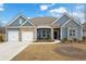 Charming home with blue siding, stone accents, a well manicured lawn, and a two-car garage at 7438 Jennadee Dr, Fairburn, GA 30213