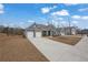 Exterior view of a blue home with stone accents, a long driveway and manicured lawn at 7438 Jennadee Dr, Fairburn, GA 30213