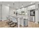 Bright kitchen featuring white cabinets, an island with seating, and stainless steel appliances at 7438 Jennadee Dr, Fairburn, GA 30213