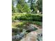 Spacious backyard with garden beds showcasing flowers, vegetables, a stone pathway, and a lush lawn, perfect for outdoor living at 437 Westmeath Sw Dr, Atlanta, GA 30310