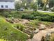 Well-manicured backyard featuring garden beds with flowers and vegetables, lush grass, and a stone pathway leading to the home at 437 Westmeath Sw Dr, Atlanta, GA 30310