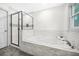 Bright bathroom features a shower, large soaking tub with marble tile and a window at 437 Westmeath Sw Dr, Atlanta, GA 30310