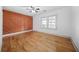 Cozy bedroom with hardwood floors, a ceiling fan, and geometric accent wall at 437 Westmeath Sw Dr, Atlanta, GA 30310