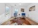 Bright bedroom featuring two chairs, stylish decor, and a large animal hide rug on hardwood floors at 437 Westmeath Sw Dr, Atlanta, GA 30310