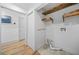 Well-organized laundry room with closet, floating wooden shelves, and modern fixtures at 437 Westmeath Sw Dr, Atlanta, GA 30310
