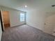 Cozy bedroom includes neutral walls, plush carpeting, closet, and natural light from the window at 7717 Sudbury Cir, Covington, GA 30014