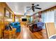 Spacious living room showcasing wood paneling, hardwood floors, and a brick fireplace under a multi-blade ceiling fan at 3354 Wakefield Dr, Decatur, GA 30034