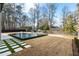 A modern pool and spa are surrounded by green grass pavers and a stained fence at 185 Pebble Trl, Alpharetta, GA 30009