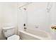 Bathroom featuring a white tiled tub and toilet with brass fixtures at 406 Vinings Forest Se Cir, Smyrna, GA 30080