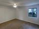 An empty bedroom with carpet, a ceiling fan, and a window letting in natural light at 6090 Wintergreen Rd # 1A3, Norcross, GA 30093