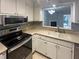 The well-lit kitchen includes a stainless steel oven, a stainless steel microwave, and white cabinets at 6090 Wintergreen Rd # 1A3, Norcross, GA 30093