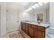 Bathroom featuring dual vanities with white countertops, wooden cabinets, and a large mirror at 164 Owens Farm Ln, Woodstock, GA 30188