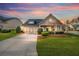 Charming home featuring a manicured lawn, two-car garage, and inviting curb appeal at sunset at 164 Owens Farm Ln, Woodstock, GA 30188