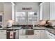 This kitchen showcases granite countertops, stainless steel sink, white cabinetry, modern appliances and natural lighting from two windows at 1721 Mcgarity Rd, Temple, GA 30179