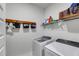 Efficient laundry room with modern washer and dryer, plus overhead storage and numbered basket storage above the appliances at 1721 Mcgarity Rd, Temple, GA 30179