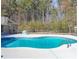 Backyard pool area with mature trees, a deck and a fenced perimeter at 3410 Church Rd, Villa Rica, GA 30180