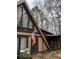 The exterior shows an A-frame home on a wooded lot with leaves covering the ground at 5435 Hearn Rd, Ellenwood, GA 30294