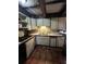 A full kitchen featuring tile backsplash, vintage cabinets, and terra cotta flooring at 5435 Hearn Rd, Ellenwood, GA 30294