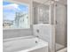 Modern bathroom showcasing tiled bathtub and shower with glass door at 3848 Pressley Ln # 26, Powder Springs, GA 30127