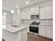 Bright kitchen featuring white cabinetry, stainless steel appliances, granite countertops, and stylish pendant lighting at 3848 Pressley Ln # 26, Powder Springs, GA 30127