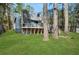 Exterior view of a raised home, showcasing a large wooden deck and a grassy yard at 462 Lakeshore Dr, Stockbridge, GA 30281