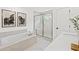 Bathroom with a walk-in shower, free-standing tub, white marble tile, and double vanity at 5760 Tillman Way, Powder Springs, GA 30127