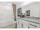 Bright bathroom featuring a tub, white vanity with gray countertop, and minimalist decor at 5760 Tillman Way, Powder Springs, GA 30127