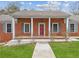 Inviting brick porch with white columns, contrasting shutters, and well-kept lawn at 3113 Melissa Ct, Douglasville, GA 30135