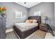 Cozy bedroom featuring a tufted headboard, decorative pillows, and side tables, illuminated by natural light at 557 Loth Wages Rd, Dacula, GA 30019