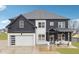 Two-story modern farmhouse with black siding, white brick, and a spacious three-car garage at 557 Loth Wages Rd, Dacula, GA 30019