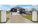 Beautiful two-story home with manicured front lawn, concrete driveway, and stately brick entrance pillars at 557 Loth Wages Rd, Dacula, GA 30019
