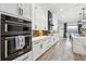 Contemporary kitchen featuring white cabinets, stainless steel appliances, and hardwood floors at 557 Loth Wages Rd, Dacula, GA 30019