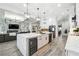 Modern kitchen boasts white cabinets, marble island, stainless steel appliances, and open layout to living area at 557 Loth Wages Rd, Dacula, GA 30019
