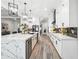 Elegant kitchen with white cabinets, marble countertops, stainless steel appliances, and hardwood floors at 557 Loth Wages Rd, Dacula, GA 30019