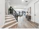 Open-concept space with hardwood floors, staircase, modern decor, and a living area beyond at 557 Loth Wages Rd, Dacula, GA 30019