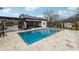 Inviting pool area with stylish outdoor kitchen, bar seating, and comfortable lounge furniture at 557 Loth Wages Rd, Dacula, GA 30019
