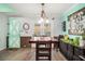 Dining area with stylish wood look floors, a modern chandelier, and a decorative barn door at 11765 Fairway Overlook, Fayetteville, GA 30215