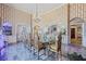 Elegant dining room with a glass-top table, gilded chairs, and views of the adjacent rooms through arched doorways at 3000 Cathedral Pl, Decatur, GA 30034