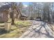 Exterior view of the home and yard, with mature trees and shed along the long driveway at 3000 Cathedral Pl, Decatur, GA 30034