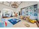 Open concept living room with elegant chandeliers, shelving, and a blue Versace rug at 3000 Cathedral Pl, Decatur, GA 30034