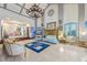 Open concept living room featuring elegant chandeliers, tiled floors, and blue accent couches at 3000 Cathedral Pl, Decatur, GA 30034
