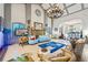 Open concept living room with an elegant chandelier, fireplace, and blue couches at 3000 Cathedral Pl, Decatur, GA 30034
