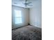 A carpeted bedroom features a ceiling fan, a window with blinds, and neutral walls at 11006 Clearwater Dr, Hampton, GA 30228