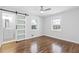 Bright bedroom with hardwood floors, a frosted glass sliding door to bathroom and two windows at 1889 Cannon St, Decatur, GA 30032