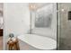 Modern bathroom featuring a soaking tub with chandelier, stone shower, and window blinds at 5305 Redfield Way, Cumming, GA 30028