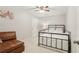 Neutral-toned bedroom boasts a metal frame bed, ceiling fan, and a cozy brown armchair in a serene setting at 5305 Redfield Way, Cumming, GA 30028